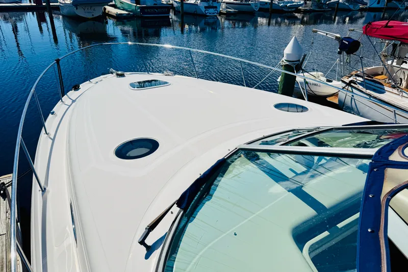 Slide: The Image of 2005 Sea Ray 340 Sundancer yacht docked at marina, showcasing sleek design and spacious deck. - 7