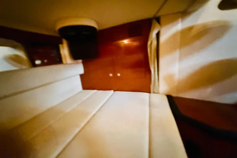 Slide: The Image of Interior cabin of 2005 Sea Ray 340 Sundancer with white seating and wooden paneling. - 47
