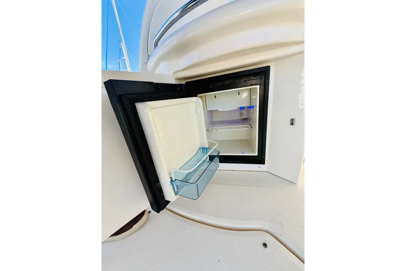 Slide: The Image of Open mini fridge on 2005 Sea Ray 340 Sundancer yacht, showcasing interior storage space. - 27