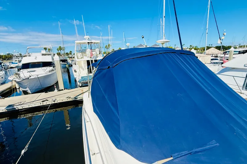 Slide: The Image of 2005 Sea Ray 340 Sundancer docked at marina, covered with blue tarp. - 33
