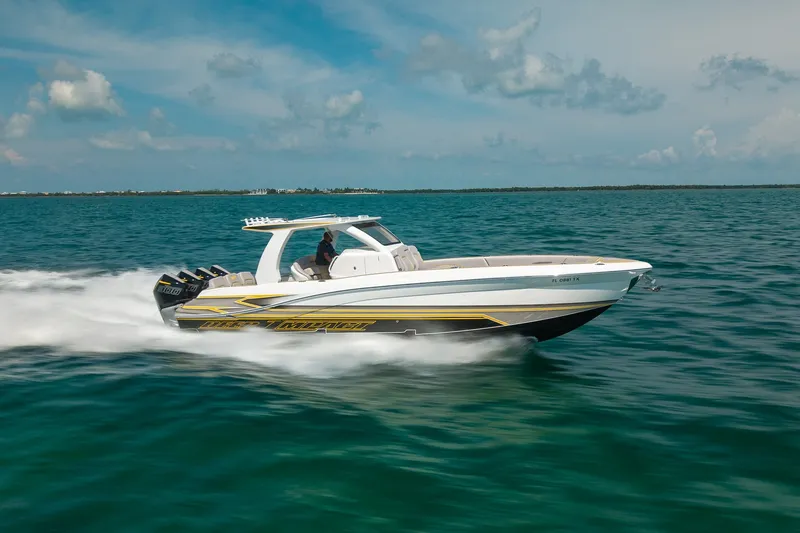 Slide: The Image of 2025 Deep Impact 369 Sport boat speeding on open water under a clear sky. - 2