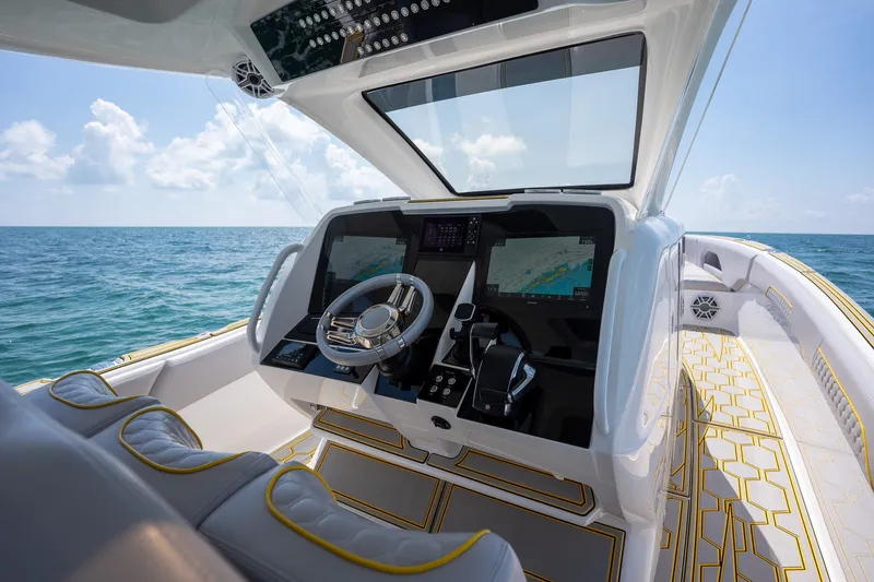 Slide: The Image of Cockpit of 2025 Deep Impact 369 Sport boat with modern navigation system, steering wheel, and ocean view. - 22