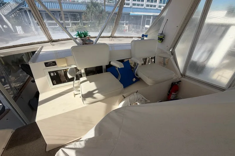 Slide: The Image of 1990 Viking 44 Motor Yacht helm with dual seats and panoramic windows. - 23