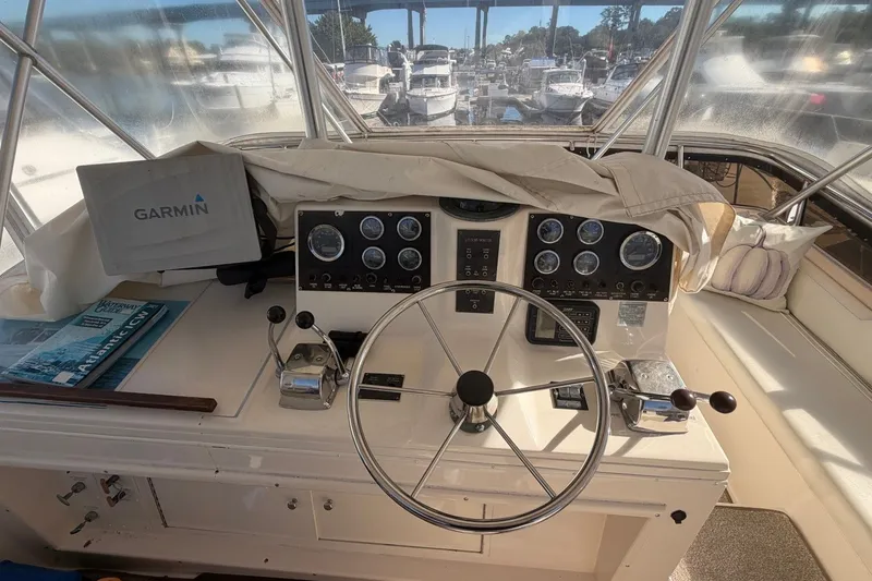 Slide: The Image of Cockpit of 1990 Viking 44 Motor Yacht with Garmin navigation system and classic steering wheel. - 24