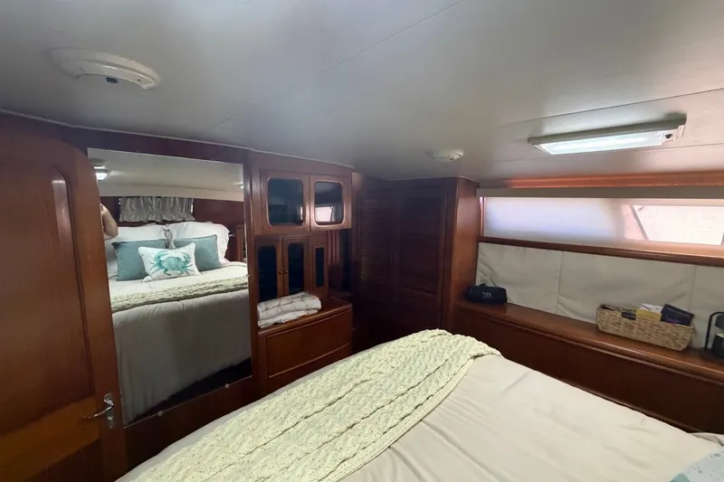Slide: The Image of Cozy bedroom interior of 1990 Viking 44 Motor Yacht with wooden cabinetry and soft lighting. - 37