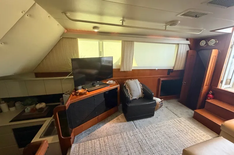 Slide: The Image of Interior of 1990 Viking 44 Motor Yacht with TV, armchair, and cozy decor. - 34