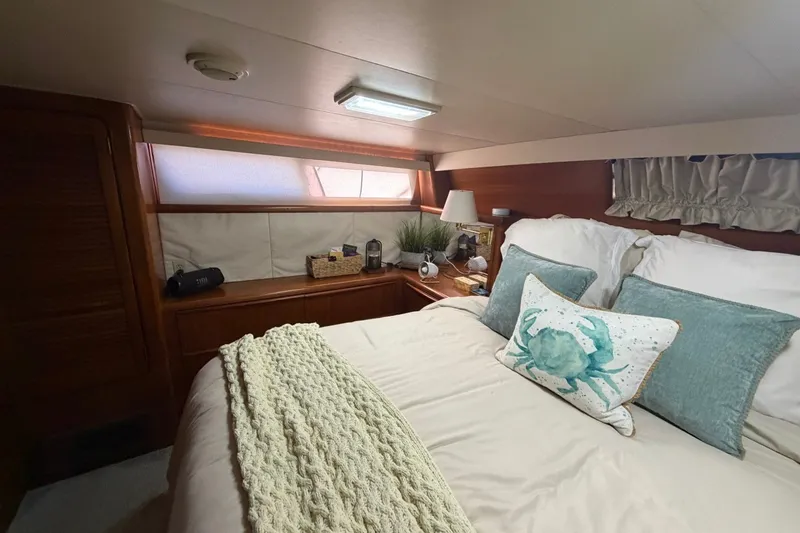 Slide: The Image of Cozy bedroom interior of 1990 Viking 44 Motor Yacht with nautical-themed decor. - 38