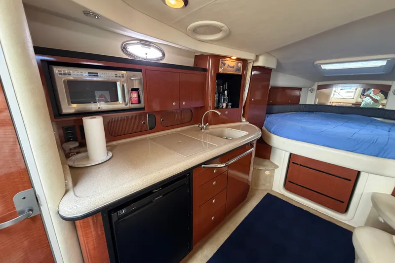 Slide: The Image of 2005 Sea Ray 340 Sundancer interior with kitchenette and cozy sleeping area. - 17