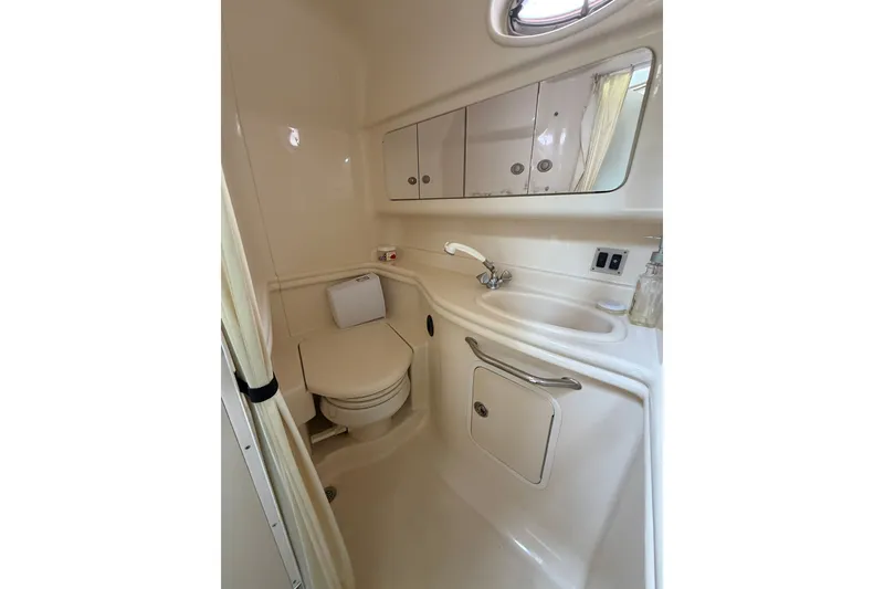 Slide: The Image of 2005 Sea Ray 340 Sundancer bathroom with sink, toilet, and storage cabinets. - 18