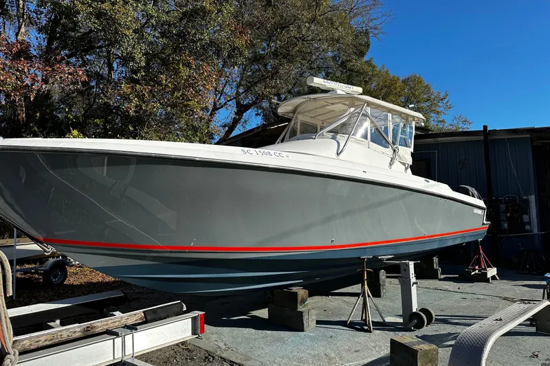 Slide: The Image of 2006 Contender 36 Fisharound boat on stands, gray hull with red stripe, outdoor setting. - 2