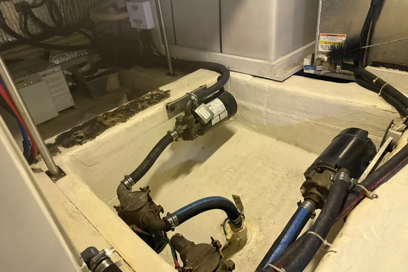 Slide: The Image of Engine room of 2001 Carver 506 Motor Yacht with visible pumps and hoses. - 51