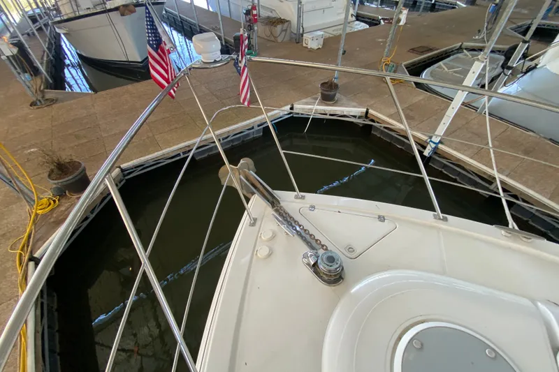 Slide: The Image of 2001 Carver 506 Motor Yacht docked, featuring deck details and American flags. - 59