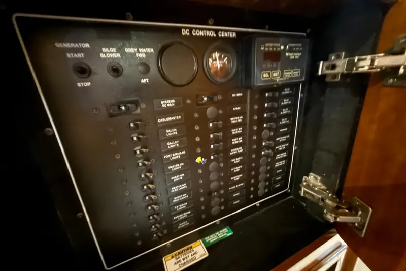 Slide: The Image of DC control panel of a 2001 Carver 506 Motor Yacht, featuring various switches and gauges. - 37