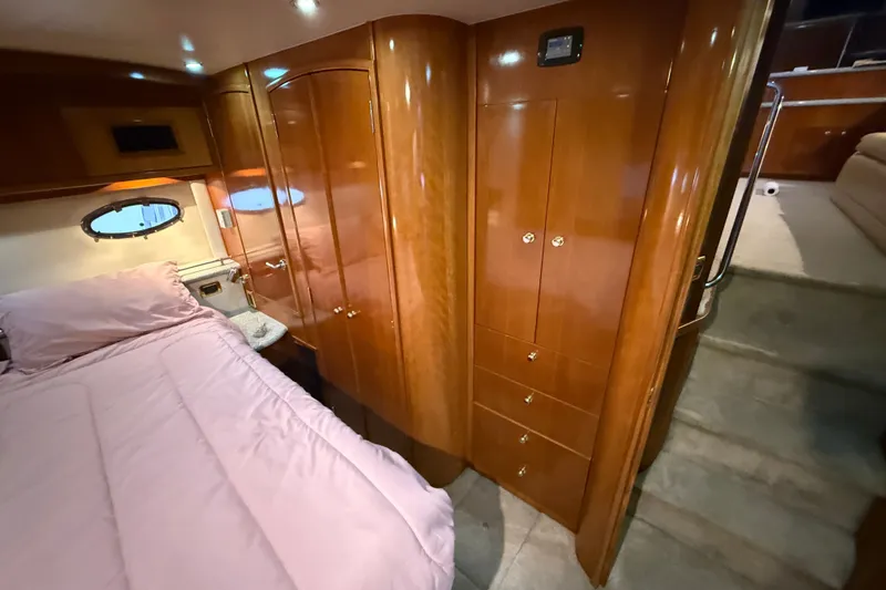 Slide: The Image of Luxurious 2001 Carver 506 Motor Yacht bedroom with wood cabinetry and pink bedding. - 28