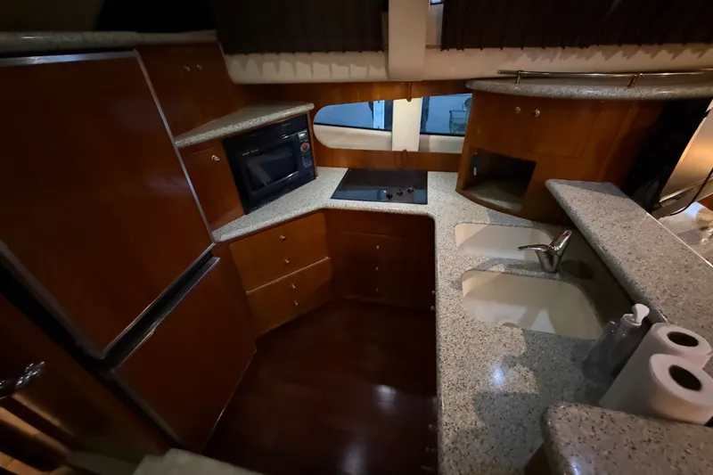 Slide: The Image of Luxurious kitchen interior of 2001 Carver 506 Motor Yacht with modern appliances and wood cabinetry. - 25