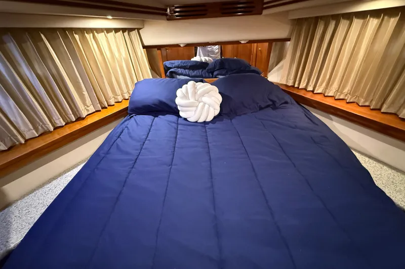 Slide: The Image of Luxurious bedroom interior of 2001 Carver 506 Motor Yacht with blue bedding and elegant curtains. - 31
