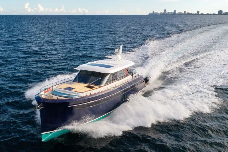 Slide: The Image of Luxurious 2021 Steeler 60S yacht cruising on open sea with city skyline backdrop. - 13
