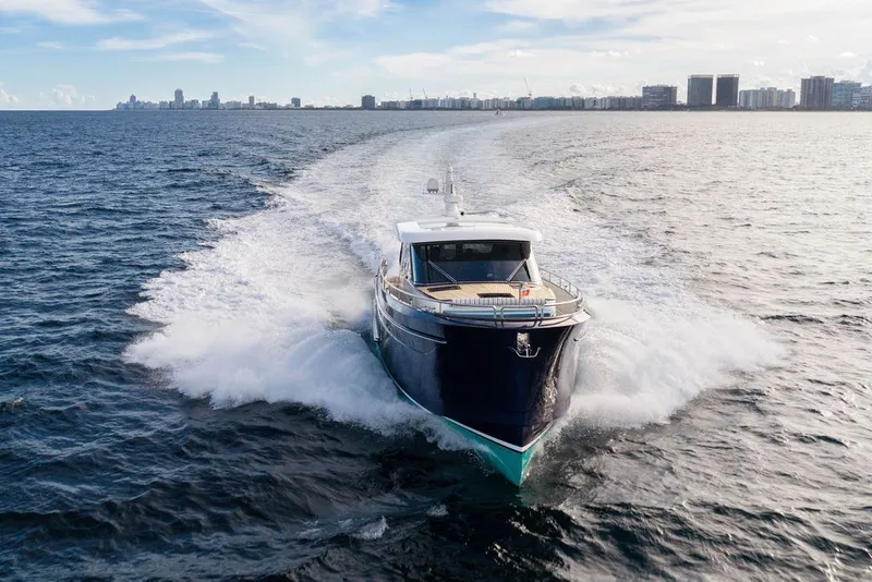 Slide: The Image of 2021 Steeler 60S yacht cruising on open water with city skyline in background. - 3