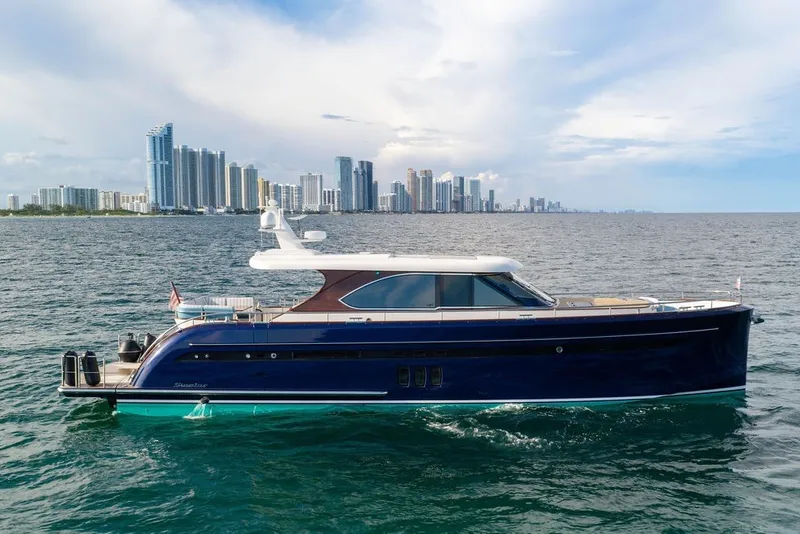 Slide: The Image of Luxury 2021 Steeler 60S yacht cruising near a city skyline on a sunny day. - 6