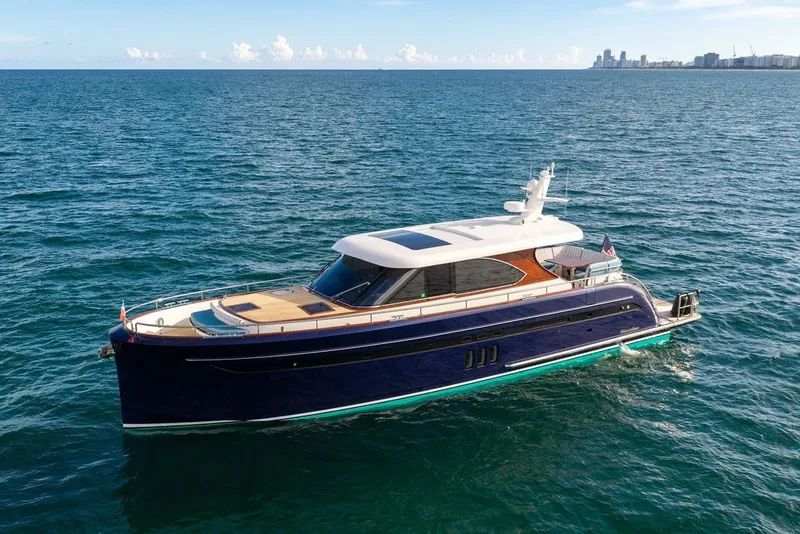 Slide: The Image of Luxury 2021 Steeler 60S yacht cruising on open sea with city skyline in background. - 8