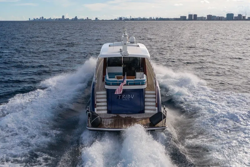 Slide: The Image of Steeler 60S yacht cruising on open water, city skyline in background, 2021 model. - 21
