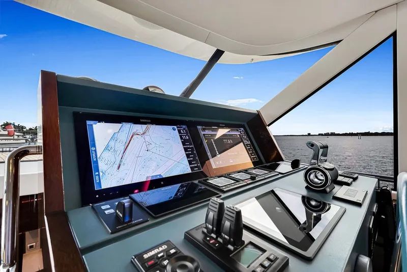 Slide: The Image of Steeler 60S 2021 yacht helm with navigation screens and controls, overlooking serene waters. - 80