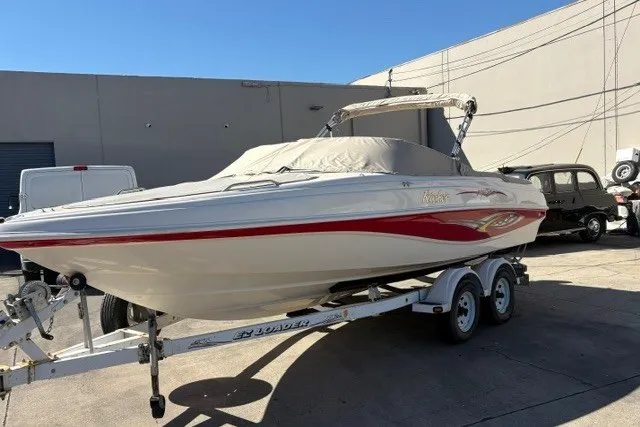 Slide: The Image of 2002 Rinker 212 Captiva Bowrider on trailer, covered, parked outdoors. - 2