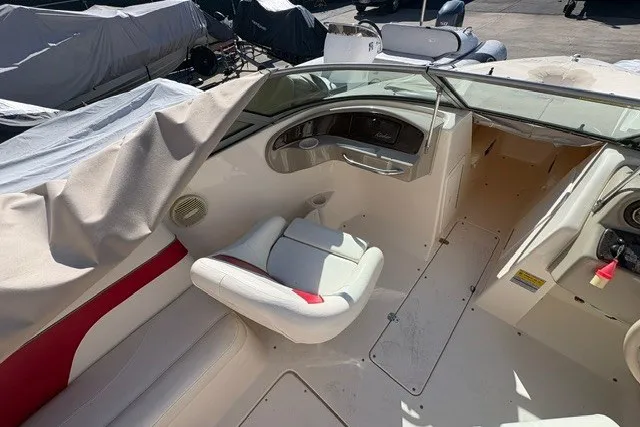 Slide: The Image of 2002 Rinker 212 Captiva Bowrider interior with white and red seating, dashboard, and steering wheel. - 9