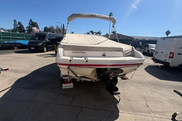 Slide: The Image of 2002 Rinker 212 Captiva Bowrider boat parked outdoors, covered and secured. - 5