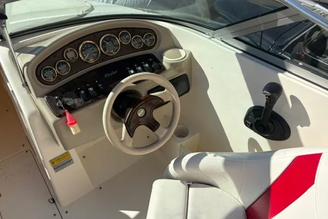 Slide: The Image of 2002 Rinker 212 Captiva Bowrider dashboard with steering wheel and control panel. - 8
