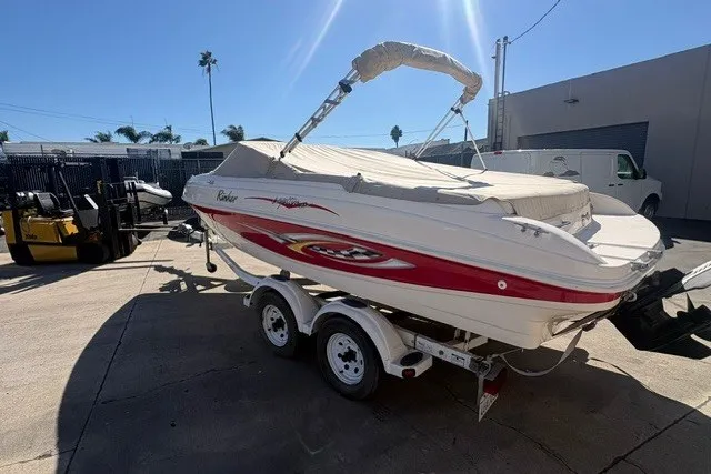 Slide: The Image of 2002 Rinker 212 Captiva Bowrider boat on trailer, parked outdoors in sunny setting. - 3
