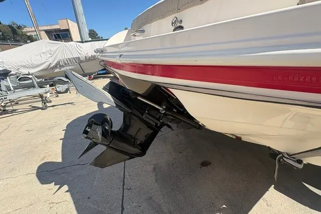 Slide: The Image of 2002 Rinker 212 Captiva Bowrider boat stern and outdrive in a marina setting. - 6