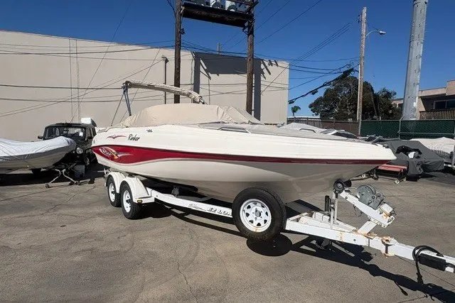 The Image of 2002 Rinker 212 Captiva Bowrider on trailer, parked outdoors in a storage area. - 0