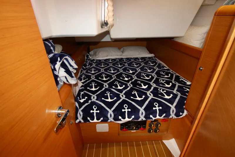 Slide: The Image of Cozy cabin interior of 2012 Jeanneau Sun Odyssey 509 with nautical-themed bedding. - 2