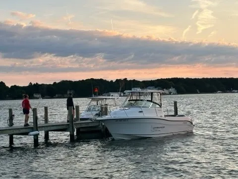 Slide: The Image of A 2003 Seaswirl Striper 2601 Walkaround O/B docked at a pier during sunset. - 3