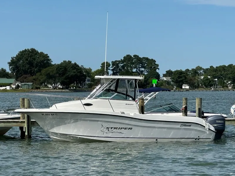 The Image of 2003 Seaswirl Striper 2601 Walkaround O/B at a dock. White boat with hardtop and outboard motor. - 0
