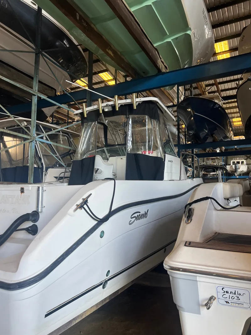 Slide: The Image of A 2003 Seaswirl Striper 2601 Walkaround O/B in a warehouse, surrounded by other boats. - 6