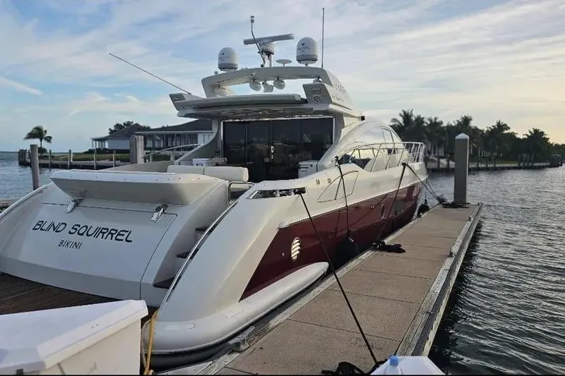 Slide: The Image of 2009 Azimut 68S yacht docked at marina, rear view with palm trees in background. - 2