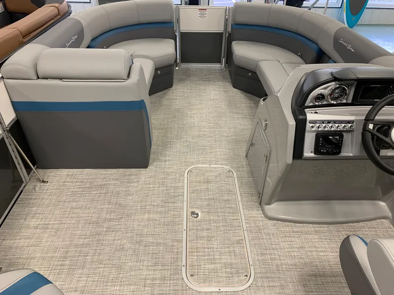 Slide: The Image of 2023 South Bay S224 RS pontoon boat interior with gray and blue seating, modern dashboard. - 17