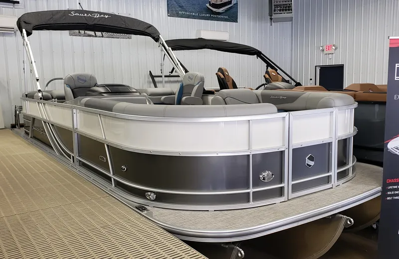 The Image of 2023 South Bay S224 RS pontoon boat in showroom, featuring sleek design and comfortable seating. - 0