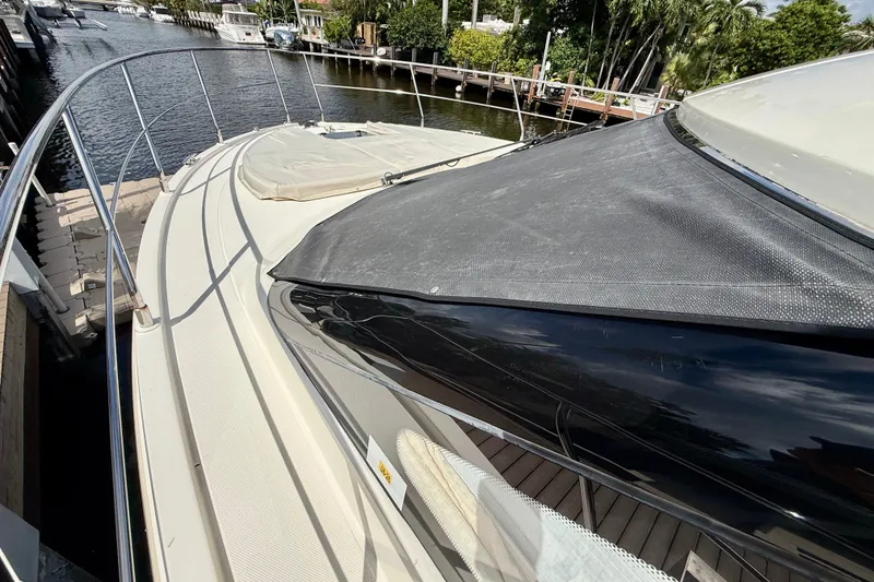 Slide: The Image of 2019 Carver C37 Coupe yacht docked by a scenic waterfront. - 24