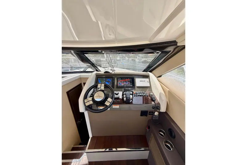 Slide: The Image of Helm of 2019 Carver C37 Coupe with modern navigation controls and steering wheel. - 37