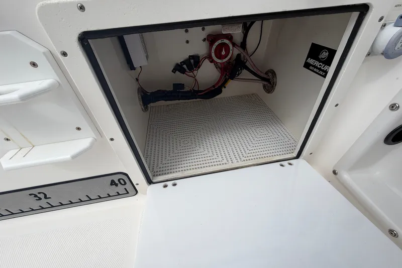 Slide: The Image of Open storage compartment in 2006 Century 2200 Walk-Around boat, showing wiring and Mercury decal. - 15