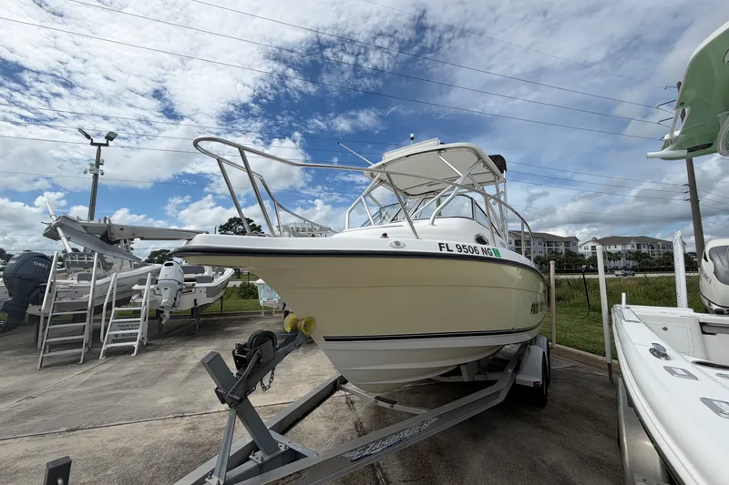 Slide: The Image of 2006 Century 2200 Walk-Around boat on trailer under cloudy sky. - 2