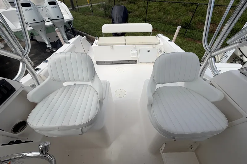 Slide: The Image of 2006 Century 2200 Walk-Around boat interior with white seating and dual outboard motors. - 11