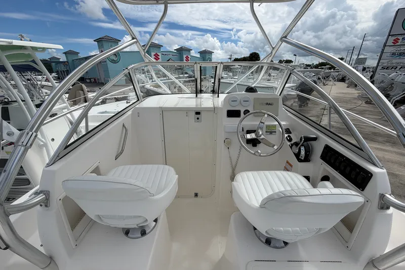 Slide: The Image of 2006 Century 2200 Walk-Around boat cockpit with white seating and steering wheel. - 6