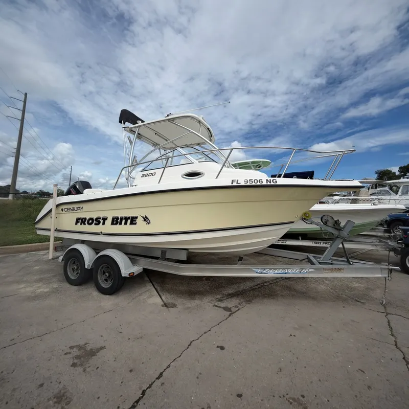 The Image of 2006 Century 2200 Walk-Around on a trailer, featuring a white hull and black T-top. - 0
