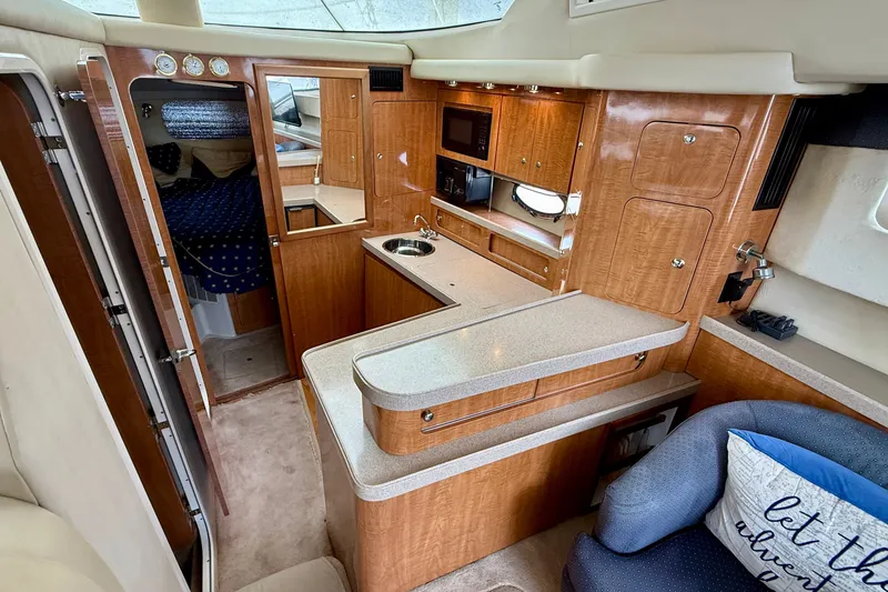 Slide: The Image of Interior of 2003 Regal Commodore 3880 yacht with wood cabinetry and compact kitchen area. - 38