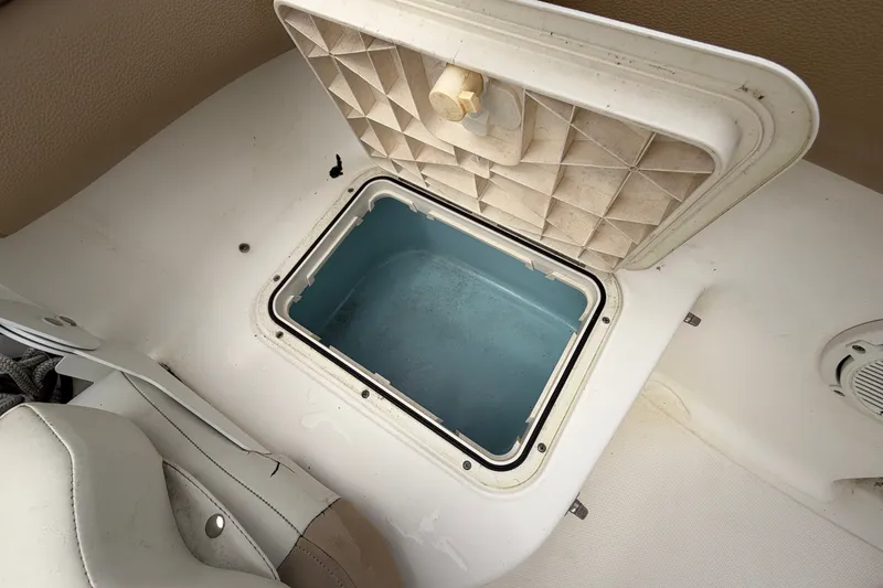 Slide: The Image of Open storage compartment on 2020 Pioneer 202 Islander boat, featuring a blue interior. - 14