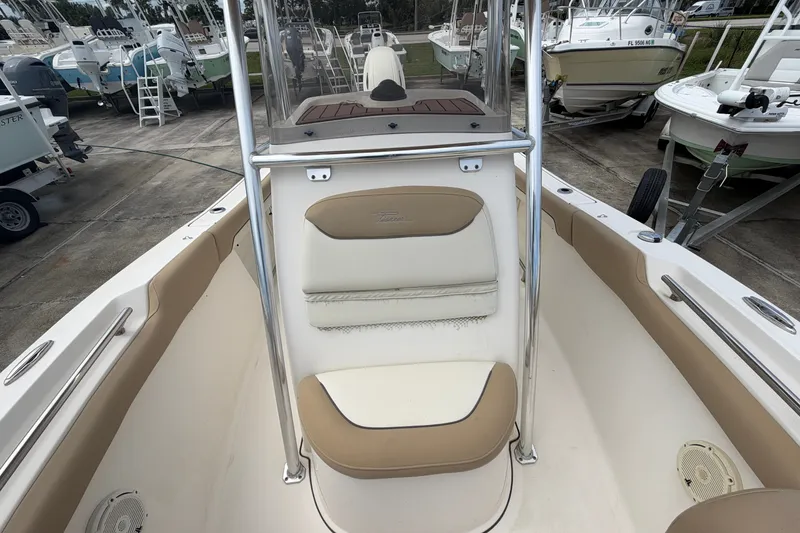 Slide: The Image of 2020 Pioneer 202 Islander boat interior with tan and white seating, docked among other boats. - 11